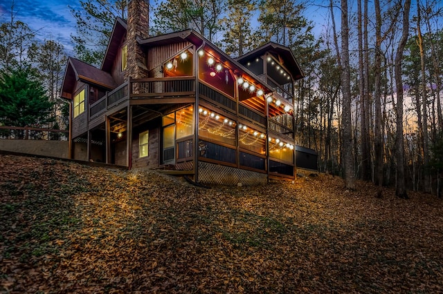 back house at dusk with a balcony