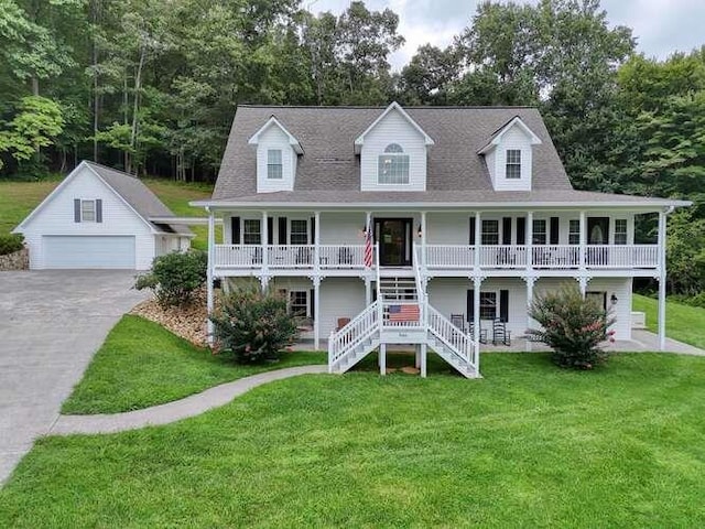 view of front of property with a garage, covered porch, an outdoor structure, and a front yard