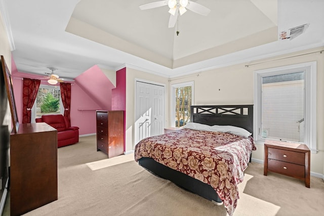 carpeted bedroom with vaulted ceiling, visible vents, a raised ceiling, and a ceiling fan