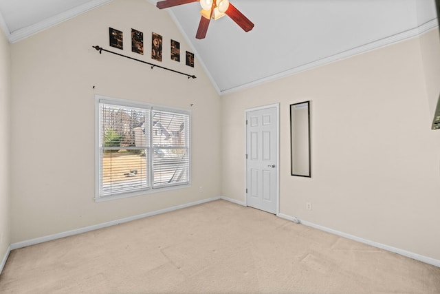 carpeted spare room with baseboards, ceiling fan, high vaulted ceiling, and crown molding