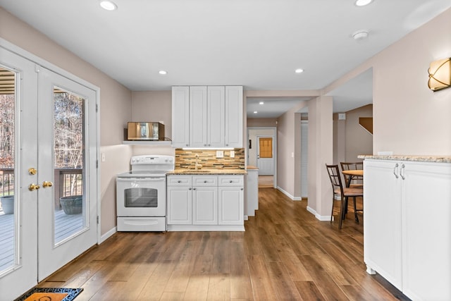 kitchen featuring electric stove, dark wood-style flooring, backsplash, white cabinetry, and a sink