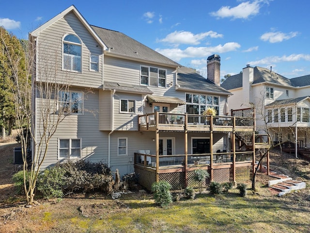 back of property with a chimney, a deck, and central AC unit