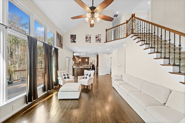 living area featuring recessed lighting, dark wood-style flooring, stairway, and a towering ceiling