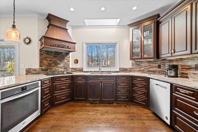 kitchen featuring stainless steel appliances, dark wood-type flooring, a sink, ornamental molding, and custom exhaust hood