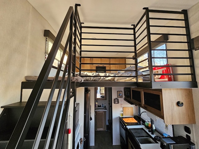 staircase featuring a towering ceiling and sink