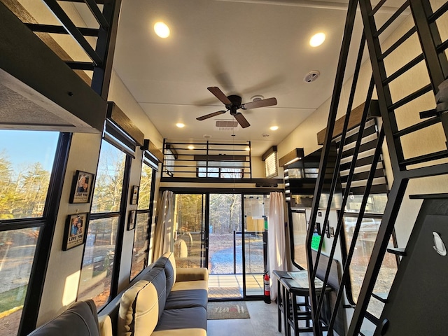 interior space with ceiling fan, plenty of natural light, and concrete flooring