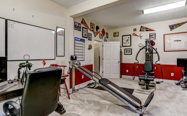 exercise area with carpet flooring and a textured ceiling