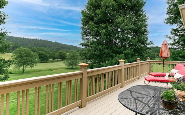 wooden deck featuring a lawn