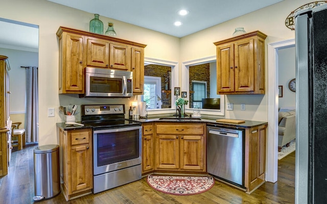 kitchen with stainless steel appliances, sink, and wood-type flooring