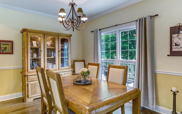 dining area featuring ornamental molding, hardwood / wood-style floors, and a chandelier