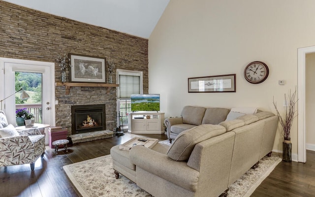 living room featuring high vaulted ceiling, dark hardwood / wood-style flooring, and a stone fireplace