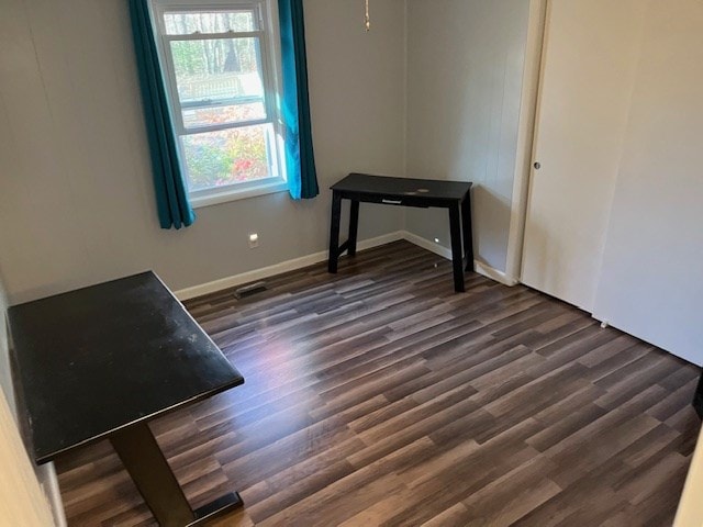 empty room with dark hardwood / wood-style flooring