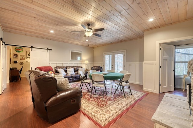 83 Nathans Path, Young Harris, GA 30582 - living area with a wainscoted wall, ceiling fan, wood finished floors, a barn door, and wooden ceiling