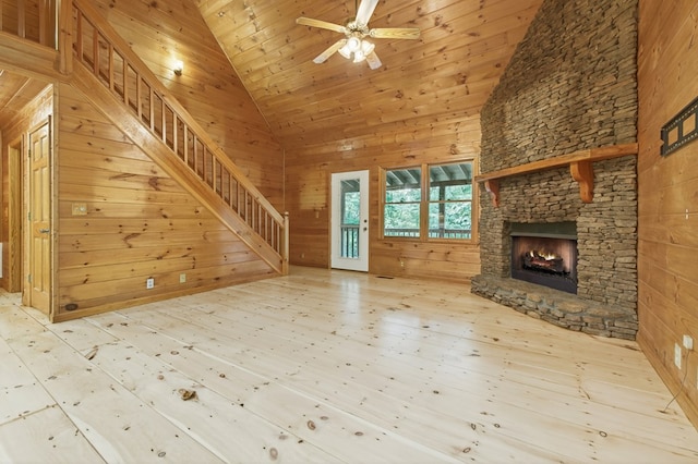 776 Mountain Oak Rd, Ellijay, GA 30536 - unfurnished living room featuring wooden walls, stairway, wood finished floors, a stone fireplace, and high vaulted ceiling