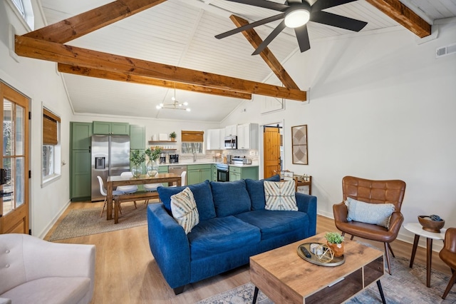 living room with light wood finished floors, baseboards, visible vents, high vaulted ceiling, and beam ceiling