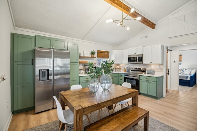 kitchen featuring vaulted ceiling with beams, light countertops, light wood-style flooring, green cabinets, and appliances with stainless steel finishes