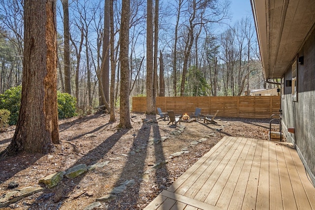 view of yard featuring a fire pit, fence, and a wooden deck