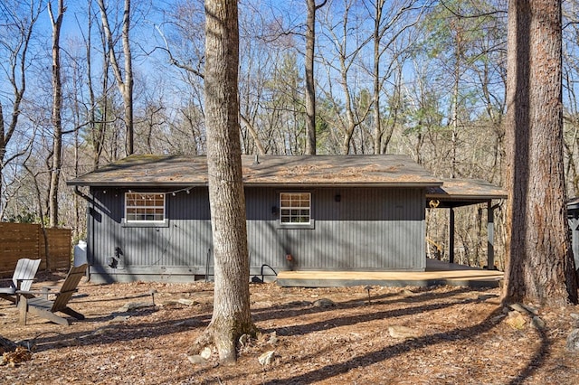 view of side of property with an attached carport and fence