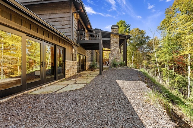 view of yard featuring french doors and a balcony