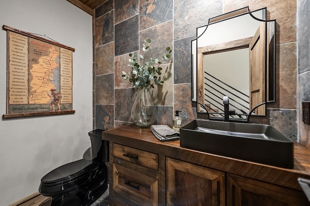 bathroom featuring vanity, toilet, and backsplash