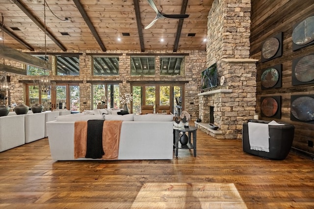 unfurnished living room with ceiling fan with notable chandelier, hardwood / wood-style flooring, high vaulted ceiling, wooden ceiling, and beamed ceiling