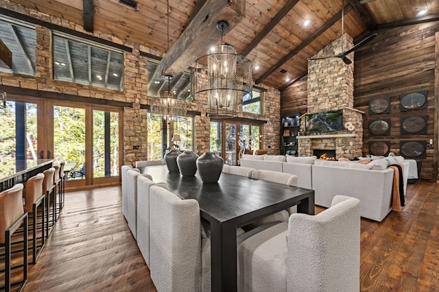 dining room with wood ceiling, beam ceiling, high vaulted ceiling, hardwood / wood-style floors, and a stone fireplace