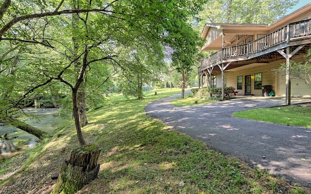 exterior space with a yard and a deck with water view