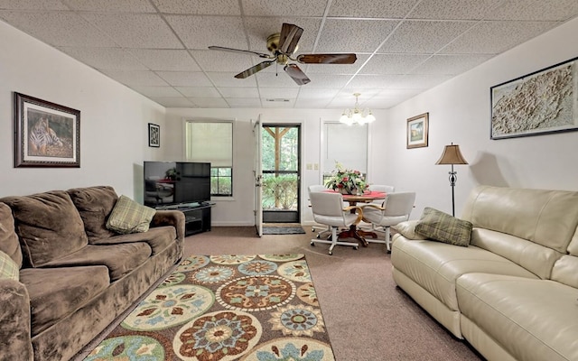 living room featuring carpet, a paneled ceiling, and ceiling fan with notable chandelier