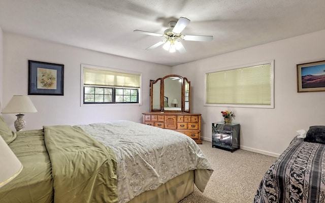 bedroom with a textured ceiling, carpet floors, and ceiling fan