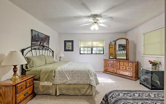 bedroom featuring ceiling fan, a textured ceiling, and light carpet