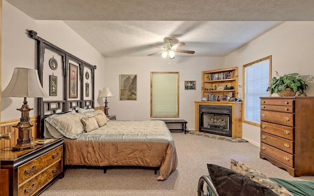 carpeted bedroom featuring a textured ceiling and ceiling fan