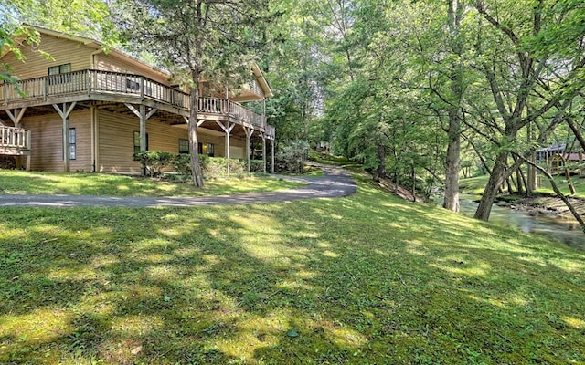 view of yard with a deck with water view