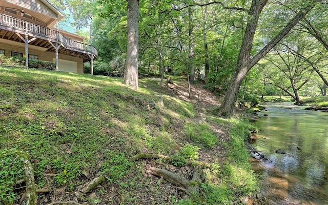 view of yard featuring a deck with water view