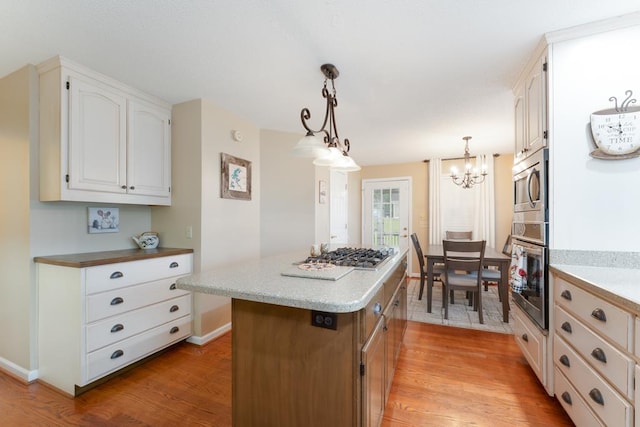1537 Victoria Woods Dr, Hiawassee, GA 30546 - kitchen featuring appliances with stainless steel finishes, baseboards, a center island, light wood finished floors, and a chandelier