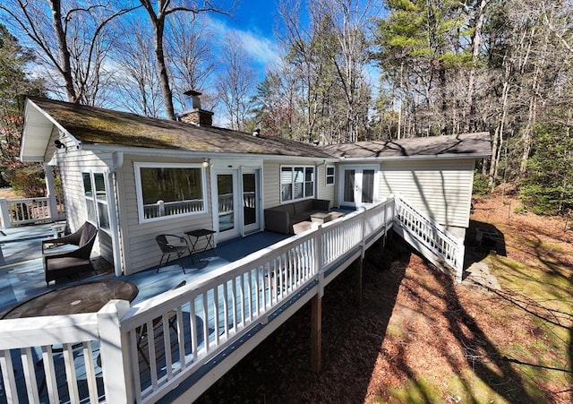 rear view of property featuring a deck, french doors, and a chimney