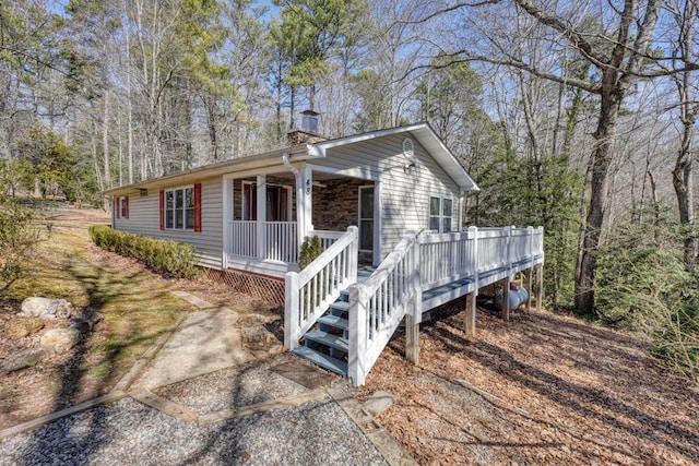 view of front of house with covered porch and a chimney