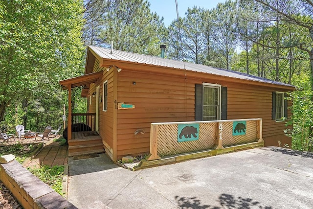 view of side of property featuring an outdoor fire pit and a patio area