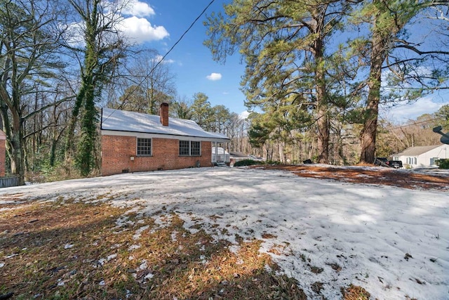 view of snow covered back of property