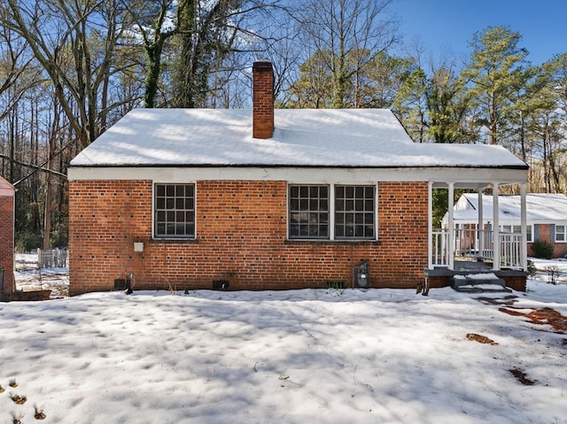 view of snow covered back of property