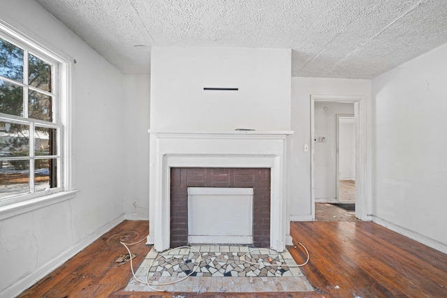 living room featuring a fireplace, dark hardwood / wood-style flooring, and a textured ceiling