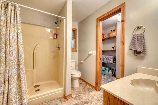 bathroom featuring walk in shower, vanity, and toilet