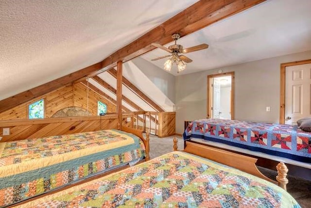 bedroom featuring lofted ceiling with beams, wood walls, a textured ceiling, ceiling fan, and carpet