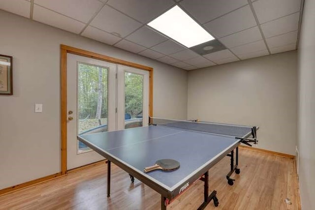 game room with light wood-type flooring and a drop ceiling