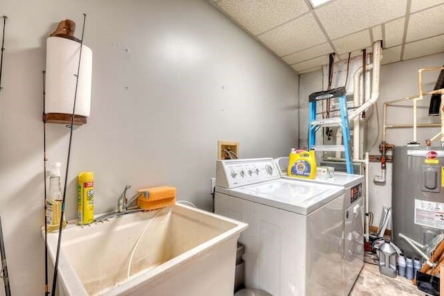 washroom with water heater, washer and dryer, and sink