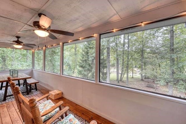 unfurnished sunroom featuring ceiling fan