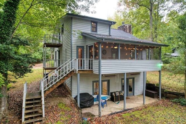 back of house with a sunroom and a patio