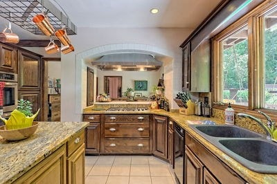 kitchen featuring light stone countertops, sink, light tile patterned floors, and appliances with stainless steel finishes