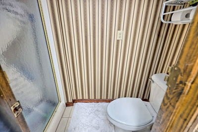 bathroom featuring tile patterned floors, toilet, and walk in shower