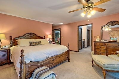 bedroom with ceiling fan and light carpet