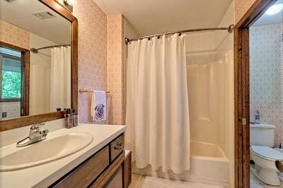 full bathroom featuring vanity, toilet, and shower / bathtub combination with curtain